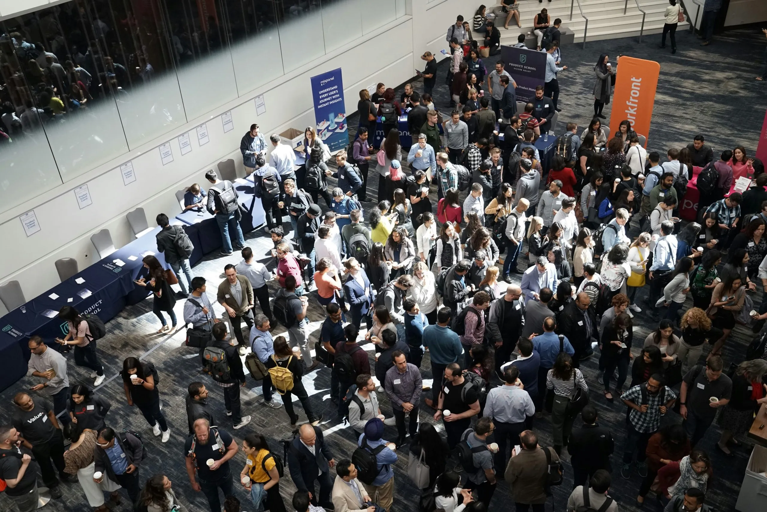 Foule de participants dans le hall d’un salon professionnel, vue en plongée
